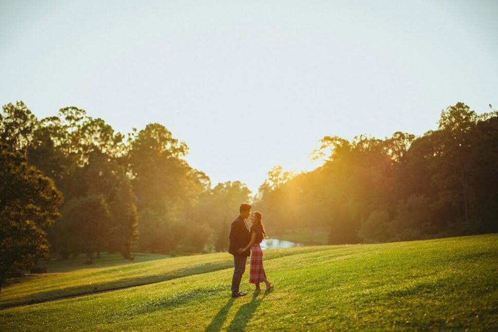 Siluet pasangan prewedding di padang rumput pinggir danau Kebun Raya Bogor saat matahari pagi menciptakan cahaya keemasan. source: sabilasyarafina