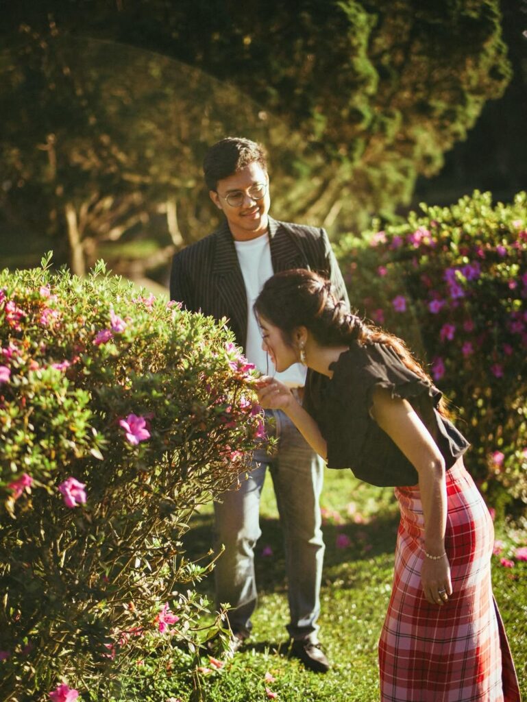 Close up pasangan prewed; perempuan mencium bunga di taman Kebun Raya Cibodas. source: sabilasyarafina